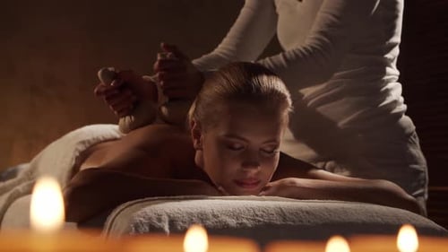 Junge, gesunde und schöne Frau wird im Spa-Salon massiert.