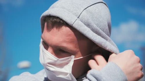 Adult Adjusting Face Mask in the Daytime