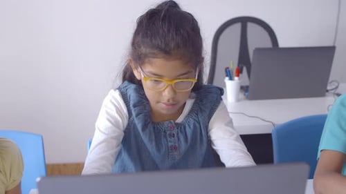 Focused Schoolgirl in Glasses Using Laptop in Class