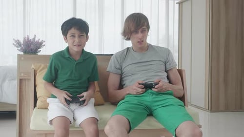 Boy and Young Adult Play Video Game at Home