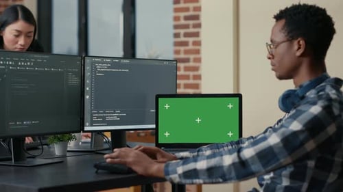 Desenvolvedor de software Escrevendo código usando teclado de computador e laptop com tela verde Chroma Key