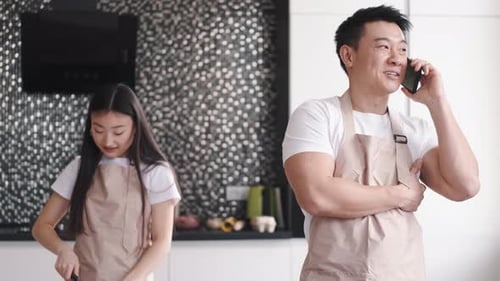 Couple Cooking Together, Man Talking on Phone