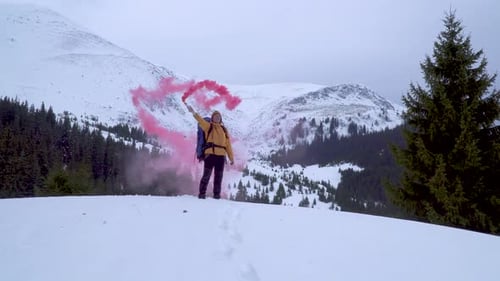 Hiker Signaling with Flare in Snowy Winter Mountains