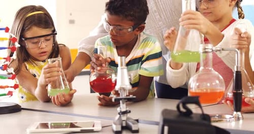 School kids doing a chemical experiment in laboratory