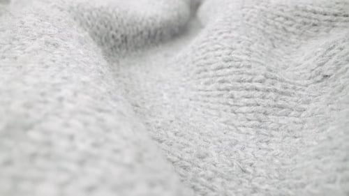 Extreme detail view of sheep wool cloth texture flowing in macro dolly shot.