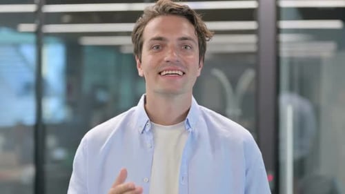 Young Man Waving and Giving Thumbs Up