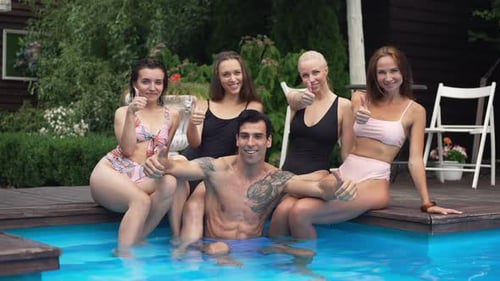 Portrait of Smiling Handsome Middle Eastern Man in Swimming Pool and Beautiful Caucasian Women at