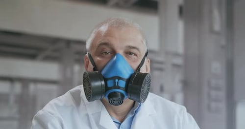 Scientist Wearing Gas Mask in Workplace Setting