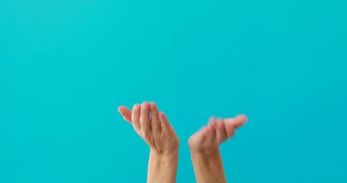 Two Hands with Palms Up Against Cyan Backdrop
