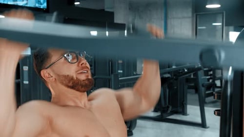 A Bearded Attractive Man Bodybuilder Doing Strength Exercises in the Gym