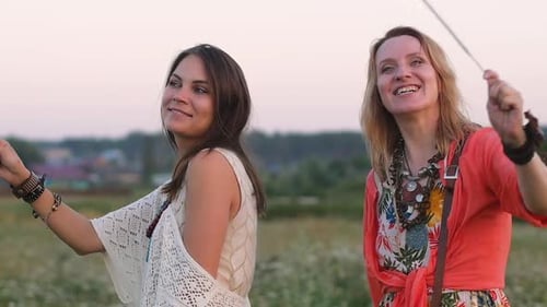 Women Friends Celebrate in a Field at Sunset