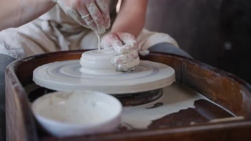 Artisan is Making Pot on Pottery Wheel Woman is Working with Piece of Clay