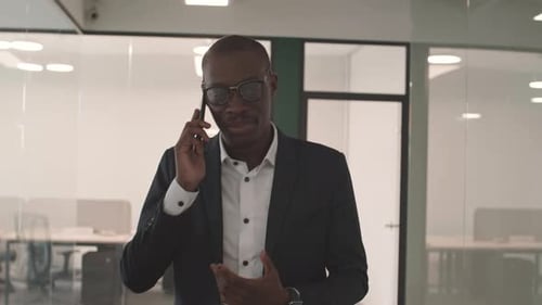 Confident Man Talking on Phone in Modern Office