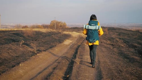 Woman Hiking on Rural Trail with Backpack