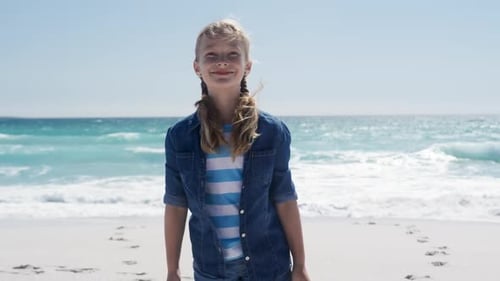 Girl standing on the beach and looking at camera