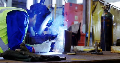 Male engineer using welding torch 4k
