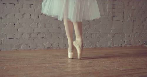 Ballerina Dancing in Pointe and White Skirt. Feet Close Up