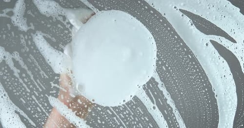 Hand With Sponge Cleaning Soapy Surface