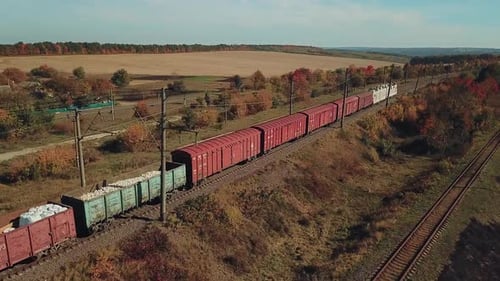 freight train with building materials is passing by rail to the destination. Aerial view