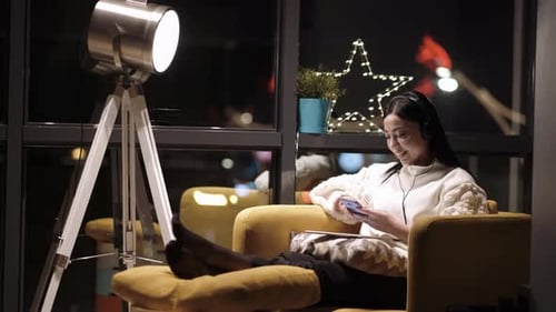Woman Relaxing at Home with Phone and Headphones