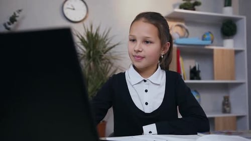 Girl Doing Homework at Desk with Laptop