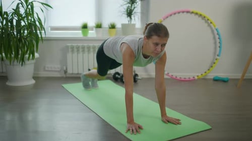 Woman Does Mountain Climber Exercise in Her Home