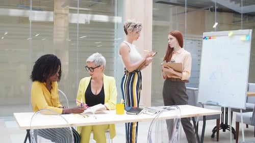 Four Women Meeting at Conference Table in Office