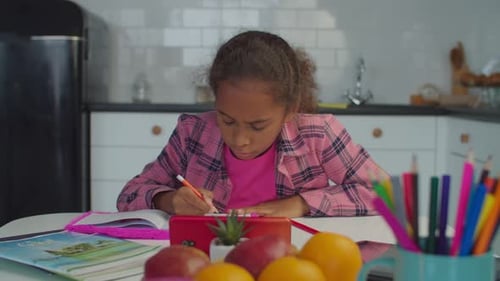 Girl Working on Homework at Kitchen Table