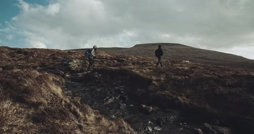 Two people walk together in the mountains