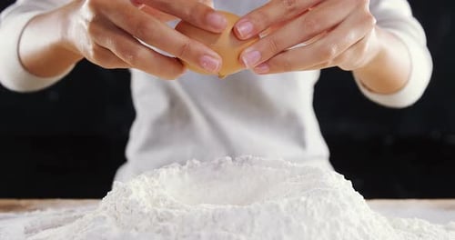 Cracking Egg Into Flour Pile Close-up