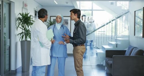 Doctors Talking in a Bright Hospital Hallway