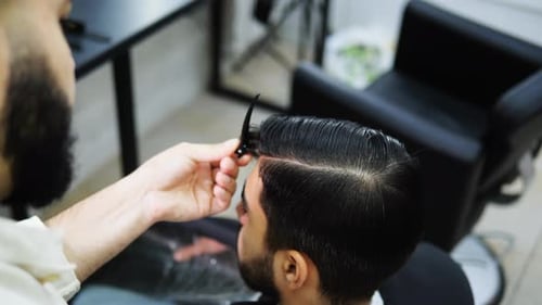 Barber Styling Man's Hair at Modern Barbershop