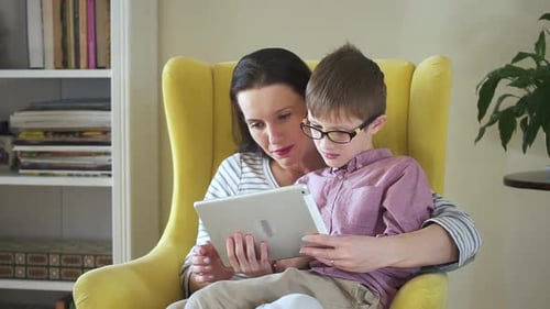 Mother and Son Looking at Tablet Together Indoors