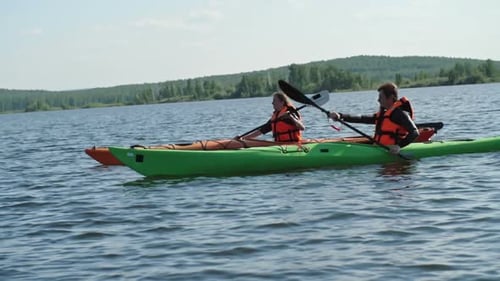 Kayaking Couple Paddling on Scenic Tropical Lake