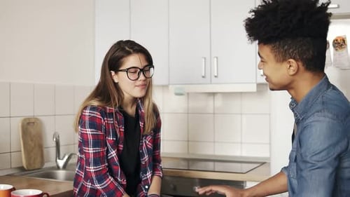 Young Adults Enjoying a Pleasant Conversation in Kitchen