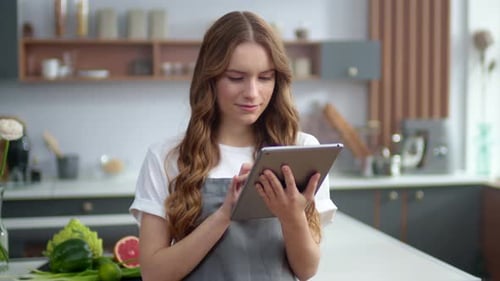 Young Woman Using Tablet in Modern Kitchen