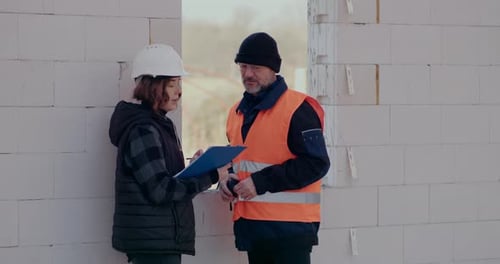 Concentrated Engineers Discussing Examining and Developing at Construction Site
