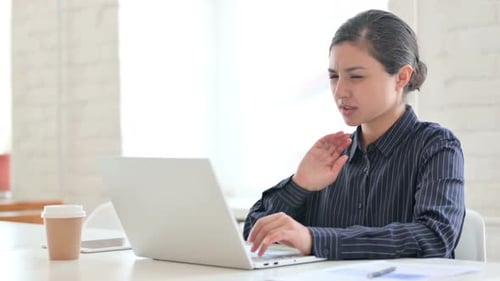 Woman Massaging Neck While Using Laptop