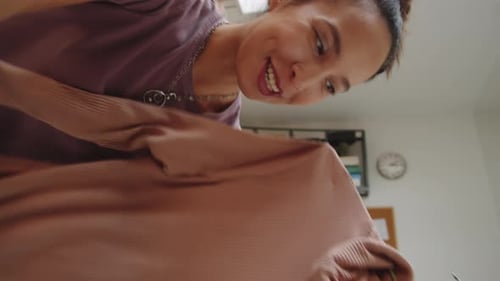 Smiling Woman Showing Fashion Garment to Camera