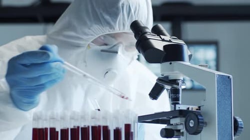 Scientist Analyzing Blood Samples with Microscope in Laboratory