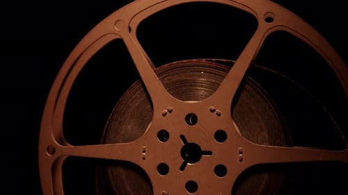 Vintage Film Reel Rotating in Dramatic Lighting