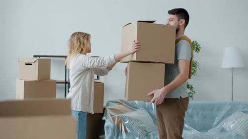 Couple Unpacking Boxes in New Home Together