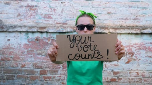 Young Adult Encourages Voting With Sign