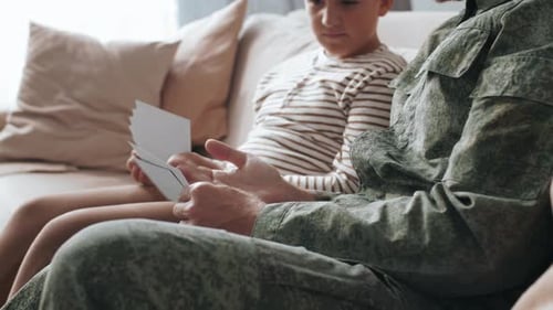 Father and Child Looking at Photos Together Indoors