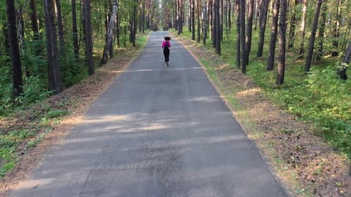 Top View of a Young Woman Runs Through the Forest.