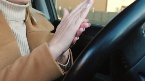 Woman Uses Hand Sanitizer in Her Car