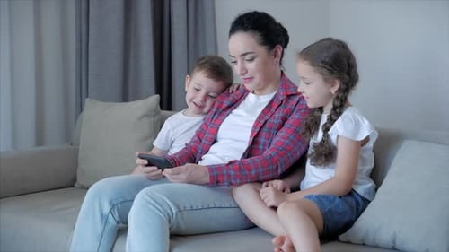 Mother and Children Enjoying Smartphone Together Indoors