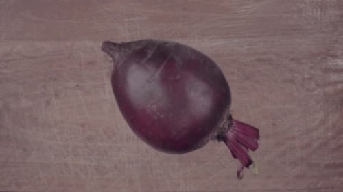 Rote Beete fällt auf schwarze Oberfläche und schneidet