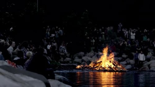 Groupe de personnes rassemblées autour d'un feu de joie pendant la Saint-Jean