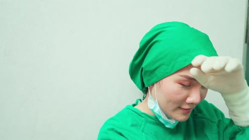 Tired Healthcare Worker in Green Surgical Scrubs